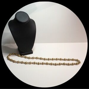 Lovely long gold tone beaded necklace.